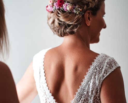 Hochzeitsfoto von Braut beim Anziehen des Brautkleides